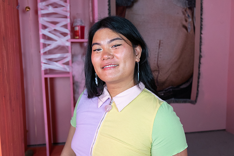 a person wearing a colorful shirt smiles at the camera