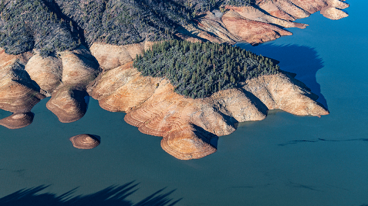 An aerial photo of Shasta Lake. The water level is low and the 
