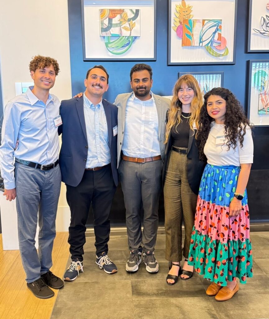 A group of young adults smile in professional clothing