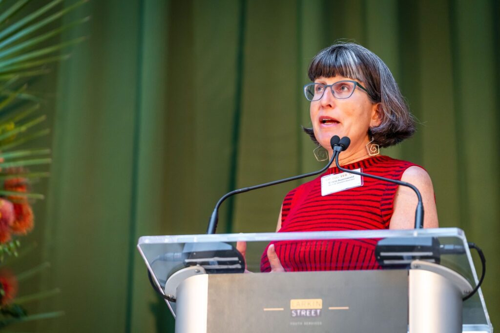 Coco Auerswald speaks into a microphone during an event she was honored at in May.
